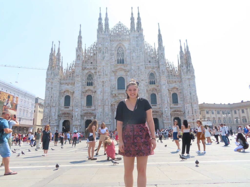 Young woman smiling at the Milan Cathedral during her year abroad in Italy.