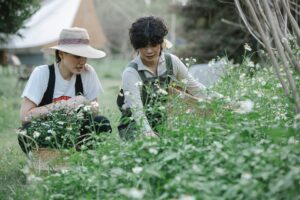 focused gardeners collecting flowers in green terrain