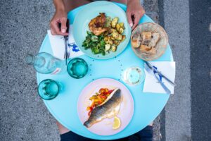 friends sitting at table with delicious food while having lunch