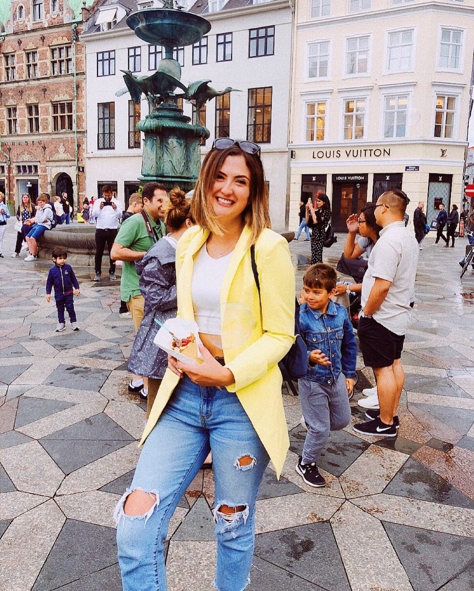 Smiling caregiver with young children in a historic European plaza