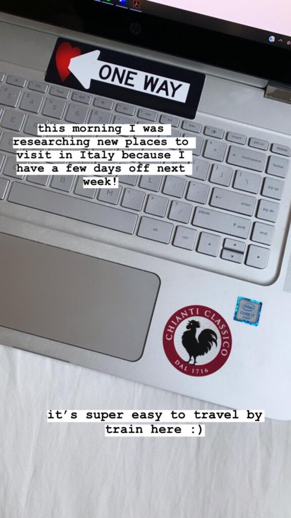 Laptop with travel stickers showing research about visiting Italy and exploring by train.