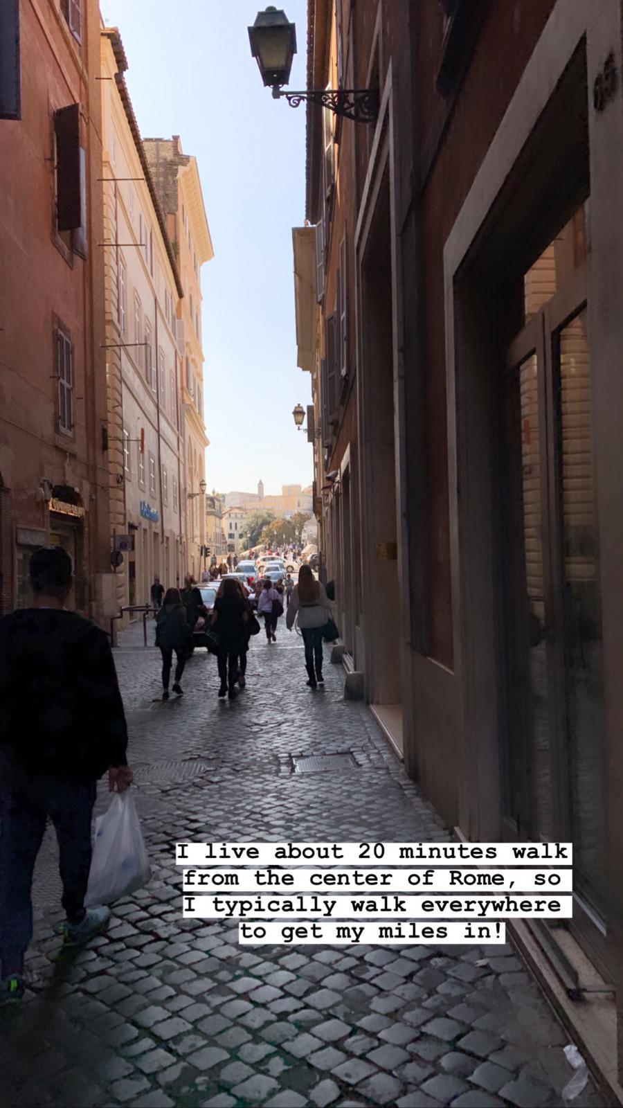 Walking through a narrow cobblestone street lined with historic terracotta buildings in Rome.