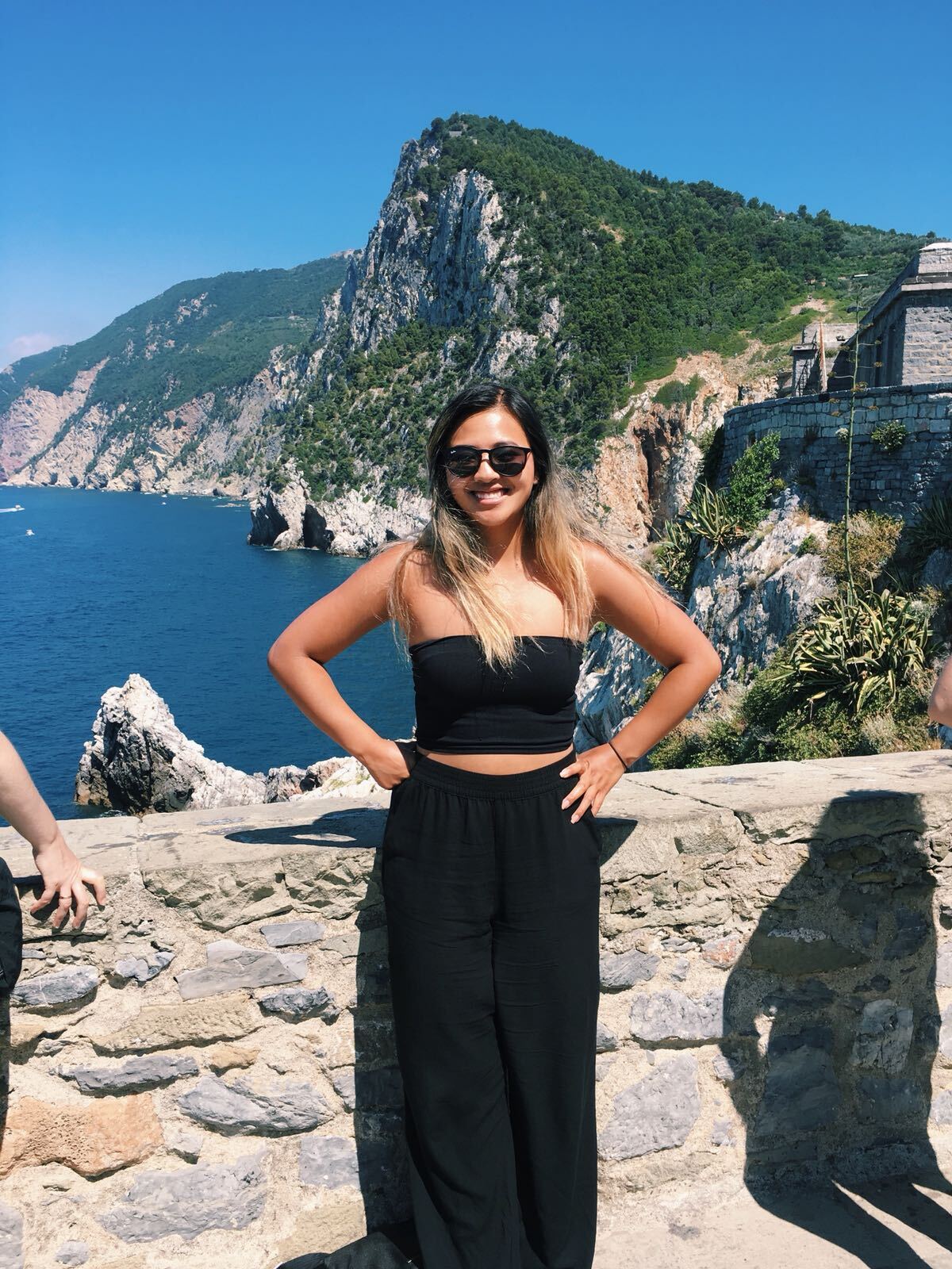 Young woman at an Italian coastal viewpoint with striking cliffs overlooking the Mediterranean.