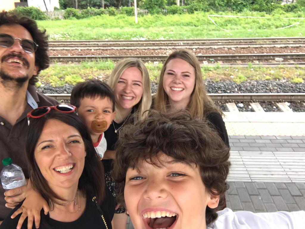 Young woman enjoying time with family at a European train station.