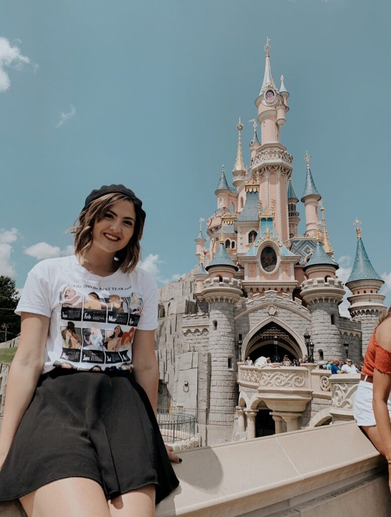 Young woman smiling at Cinderella Castle in Paris, France.