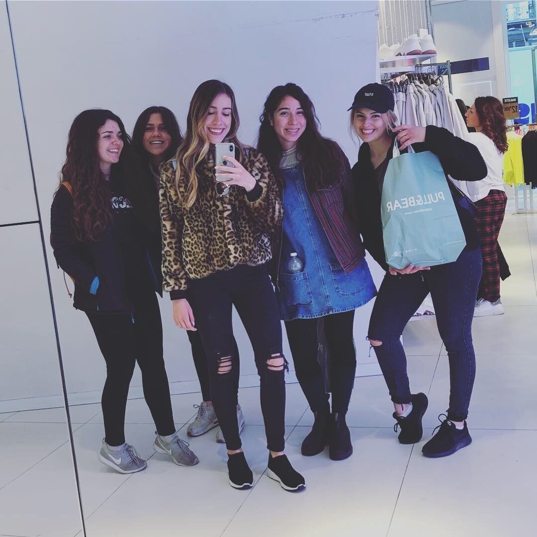 Young women laugh together while taking a selfie.